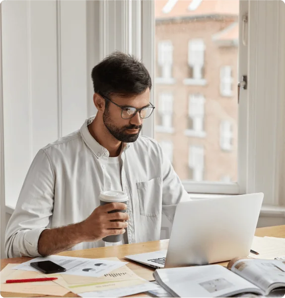 Web designer working on a laptop at his desk